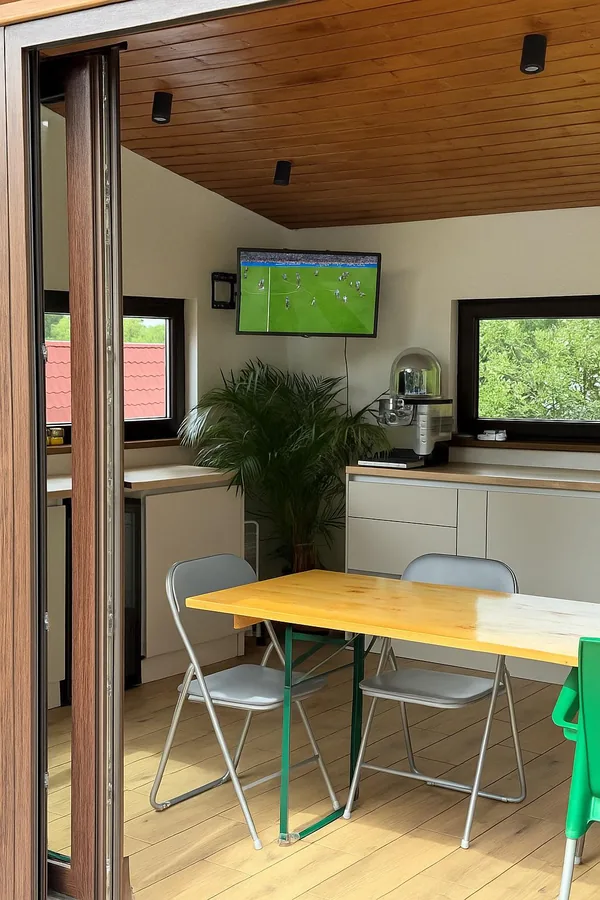 Gazebo interior with dining table, TV and summer kitchen